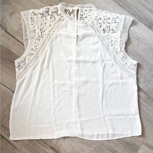 White blouse. Detailed lace trim and pearl closure.